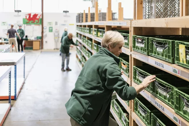 A lady checking food containers at the Cardiff food bank warehouse