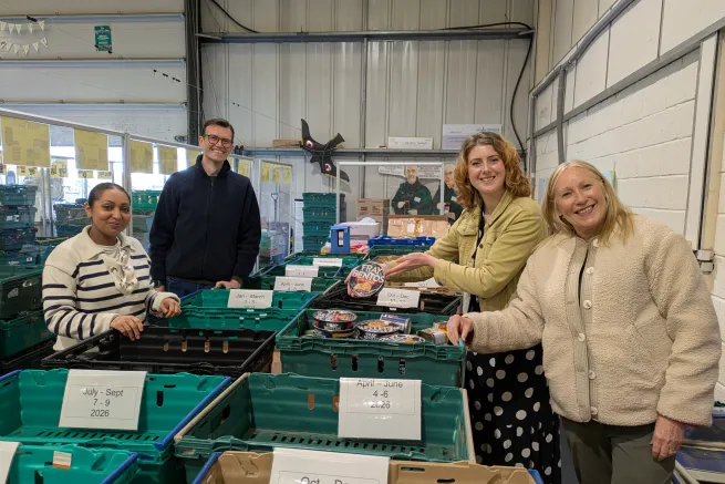 The People's Postcode Lottery sorting team in the warehouse with boxes on the table ready for items