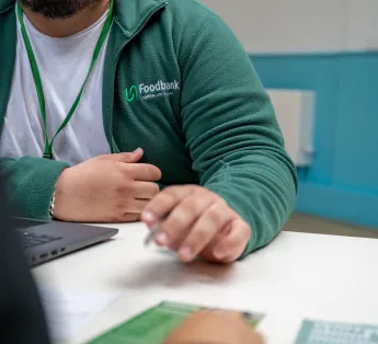 A mid body shot of a volunteer sitting down speaking to a client