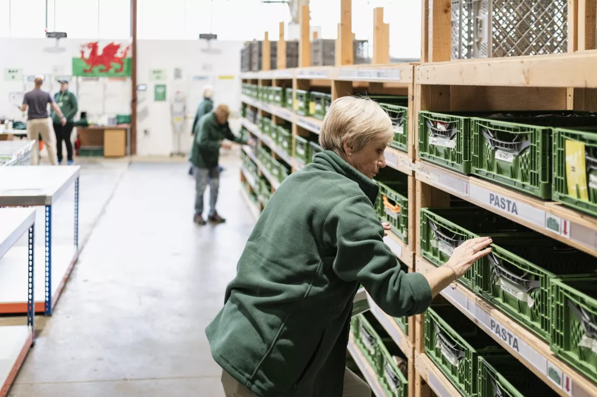 A lady checking food containers at the Cardiff food bank warehouse