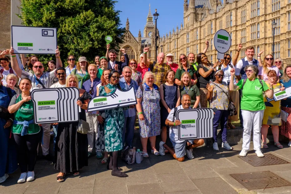 A group of people standing outside Westminster holding banners