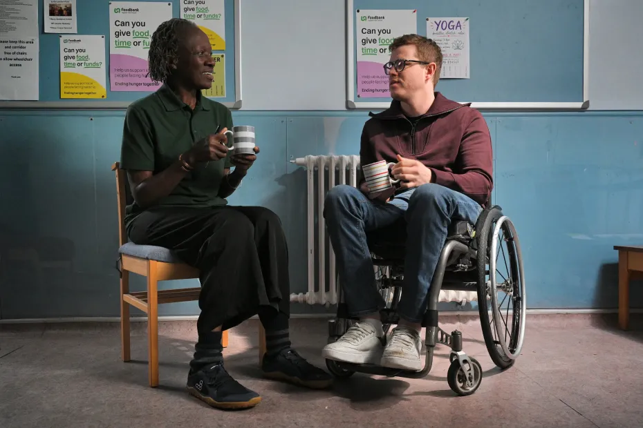 Food bank volunteer talking to a man who is in a wheelchair