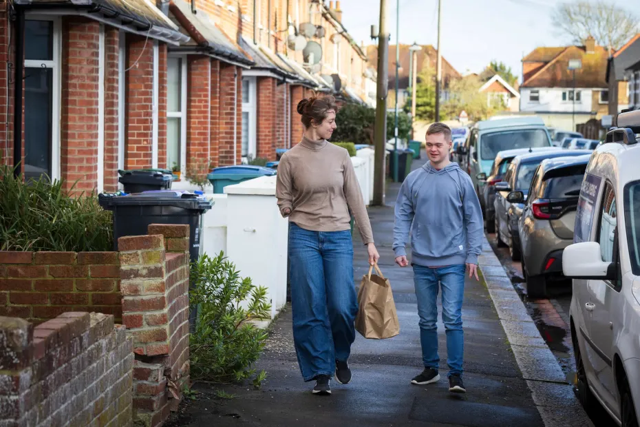 Two people walking along a residential street together