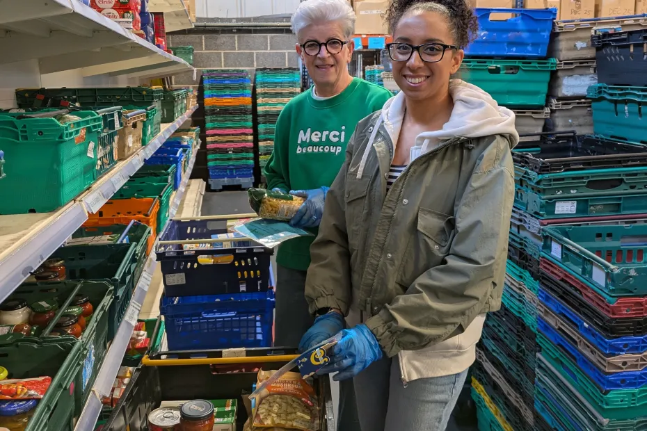 Two People's Postcode Lottery volunteers in the warehouse packaging up items into boxes