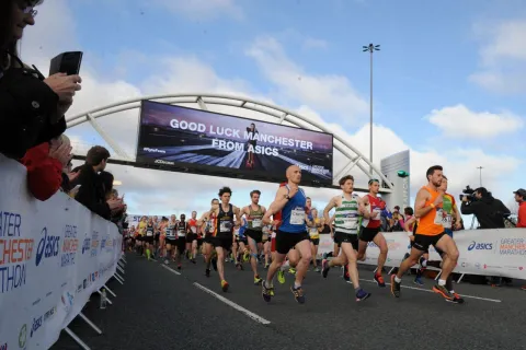 Runners going under a banner near the start of Manchester Marathon